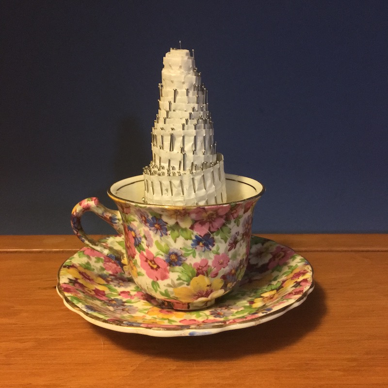 photo of a small rose covered tea cup and a roll of pins